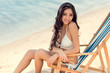 © LIGHTFIELD STUDIOS - attractive smiling girl relaxing on beach chair near the sea