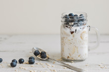 Overnight Oats With Whole Grain Cereal, Fresh Bluberries And Coconut Milk Served With A Spoon On Wooden Table. Healthy Dessert For Breakfast
