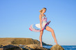 © indigo_nifght - sexy blonde on a rocky coast, playing with a dress developing in the wind.