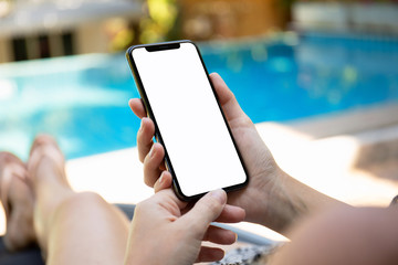 woman by the pool holding phone with an isolated screen