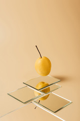 Wall Mural - one yellow pear reflecting in mirrors on beige table