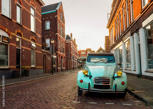 Plakaty w stylach dekoracyjnych a-stylish-retro-car-in-blue-on-the-street-in-the-dutch-city-of-vlaardingen-rotterdam-holland-the-netherlands