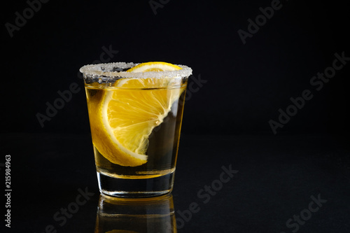 Fotomural A shot glass of tequila with salt and lime with black isolated background