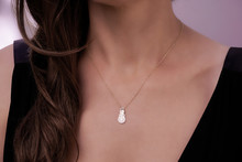 Girl Wearing A Gold Necklace With A Snowman Pendant