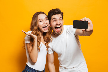 Canvas Print - Happy young couple taking selfie with mobile phone