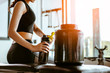 © Take Production - Relaxing after training.beautiful young woman looking away while sitting  at gym.young female at gym taking a break from workout.woman brewing protein shake.