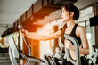 © Take Production - Fitness woman cardio workout on an elliptical.people working out on an elliptical trainer in gym.
