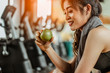 © Take Production - Athletic woman resting after working out in the gym.sitting on a treadmill and eating an apple.