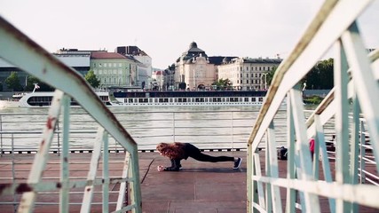 Sticker - Beautiful young woman stretching on the bridge in the city.