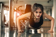 © Take Production - young woman doing push-ups at the gym.