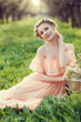 Beautiful young girl in an old dress in a pear-blossoming garden.