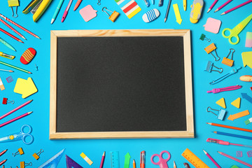 Flat lay composition with different school stationery and small chalkboard on color background
