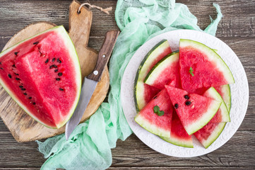 Wall Mural - Slices of a ripe watermelon on a plate on a wooden table. Top view.