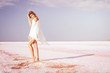 © indigo_nifght - Girl walking on the salt lake, with abstract lines of sand. The concept of tourism, recreation, Spa treatments.