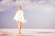 © indigo_nifght - Girl walking on the salt lake, with abstract lines of sand. The concept of tourism, recreation, Spa treatments.