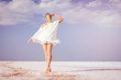 © indigo_nifght - Girl walking on the salt lake, with abstract lines of sand. The concept of tourism, recreation, Spa treatments.