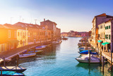Fototapeta  - Murano glass making island, water canal, bridge, boat and traditional buildings. Venice or Venezia, Italy, Europe.