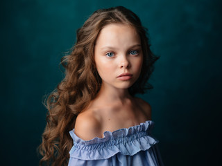 Wall Mural - girl with curls on a green background portrait