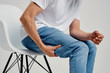 © SHOTPRIME STUDIO - man holding his leg sitting on a chair