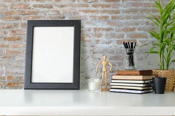 Vintage workspace with phill of books and mockup poster.