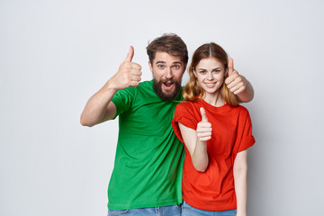 happy young couple in colorful T-shirts logo thumbs up ok