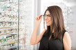 © AntonioDiaz - Hispanic woman trying on glasses she wants to buy in optician store