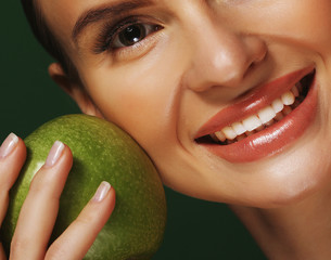 Young woman with  green apple over green background