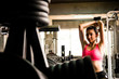 © ronnarong - Attractive young woman exercising building muscles at the gym