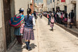 Group of children heading to school in the morning. Wearing colorful traditional clothing, walking down the street in school uniforms in Cusco, Peru.