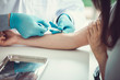 © chompoo - Close up Hand of nurse, doctor or Medical technologist in blue gloves taking blood sample from a patient in the hospital.