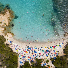 Canvas Print - View from above, aerial view of an emerald and transparent Mediterranean sea with a white beach full of beach umbrellas and tourists who relax and swim. Costa Smeralda, Sardinia, Italy.