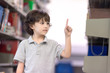 © Nattanon - Cute Boy Showing Forefinger as Pressing Touchscreen in the air. Education Concept. Setup studio shooting.