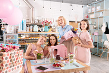 Joining Colleague. Three Appealing Happy Friends Joining Their Anticipating Colleague In Bakery