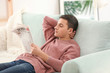 © Pixel-Shot - Handsome man reading newspaper on sofa at home