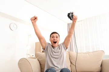 Wall Mural - Young man playing video games at home