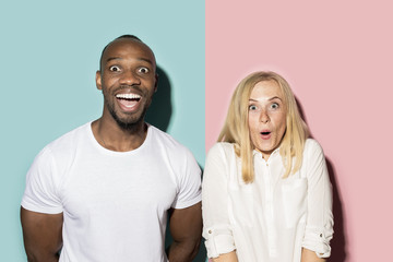 happy afro man and woman. Dynamic image of caucasian female and afro male model on pink studio.