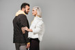 © LIGHTFIELD STUDIOS - side view of stylish couple of models in autumn outfits looking at each other isolated on grey background