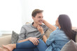 © Pixel-Shot - Happy young couple resting on sofa at home
