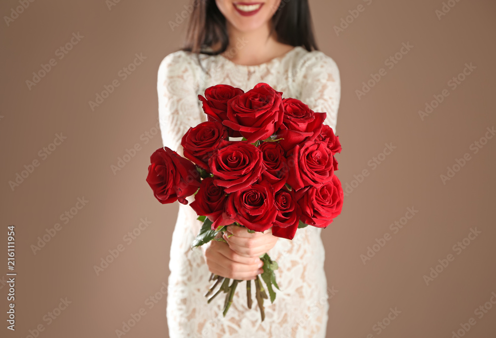 Woman holding beautiful roses on color background