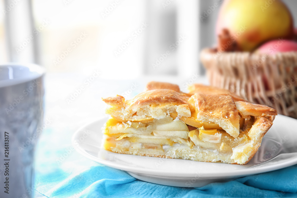 Plate with piece of delicious apple pie on table