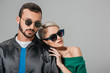 © LIGHTFIELD STUDIOS - stylish couple posing in sunglasses for fashion shoot, isolated on grey