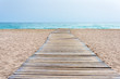 © abasler - Wooden boardwalk at beach in sand and sea in the background
