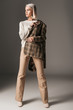 © LIGHTFIELD STUDIOS - stylish elegant model posing in autumn sweater, beige pants and tweed jacket, on grey