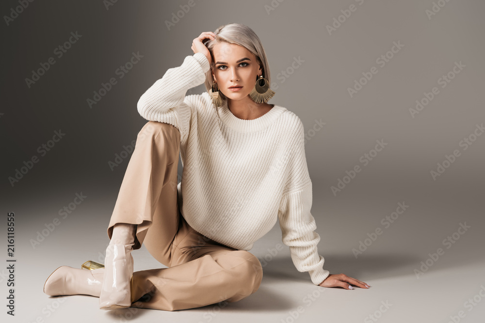 elegant beautiful girl posing in white sweater and autumn heels, on grey - obrazy, fototapety, plakaty 