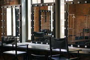 make up room with mirrors and lamp bulbs