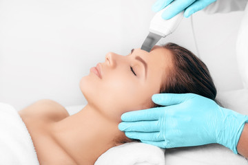 Wall Mural - Beautiful woman receiving ultrasound cavitation facial peeling. Cosmetology and facial skin care