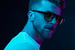 © monchak - Neon light studio close-up portrait of attractive male model in sunglasses and white t-shirt