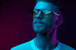 © monchak - Neon studio portrait of serious man model with mustaches and beard in sunglasses and white t-shirt