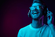 Neon Portrait Of Bearded Smiling Man In Headphones, Sunglasses, White T-shirt. Listening To Music