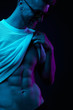 © monchak - Neon light portrait of young man in yellow glasses, pulling up t-shirt, showing abs